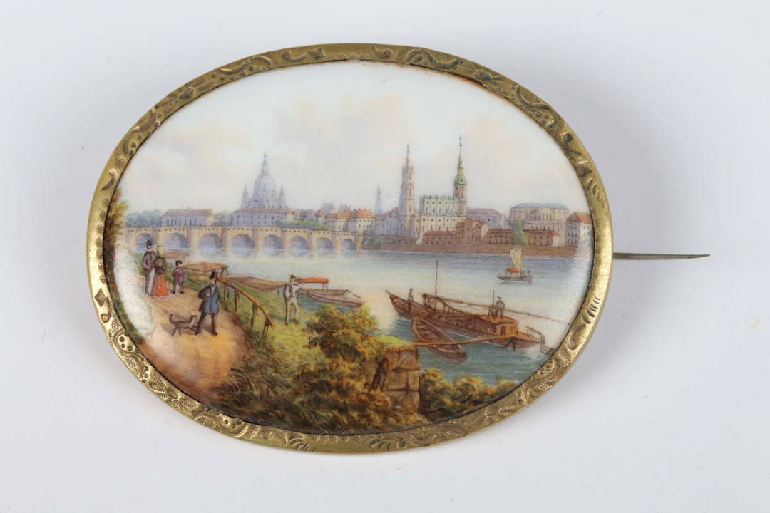 A Meissen oval porcelain brooch, painted with a view of Dresden and
