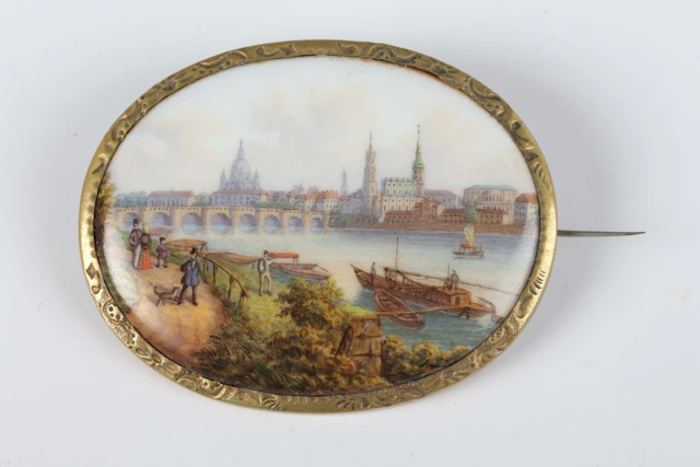 A Meissen oval porcelain brooch, painted with a view of Dresden and