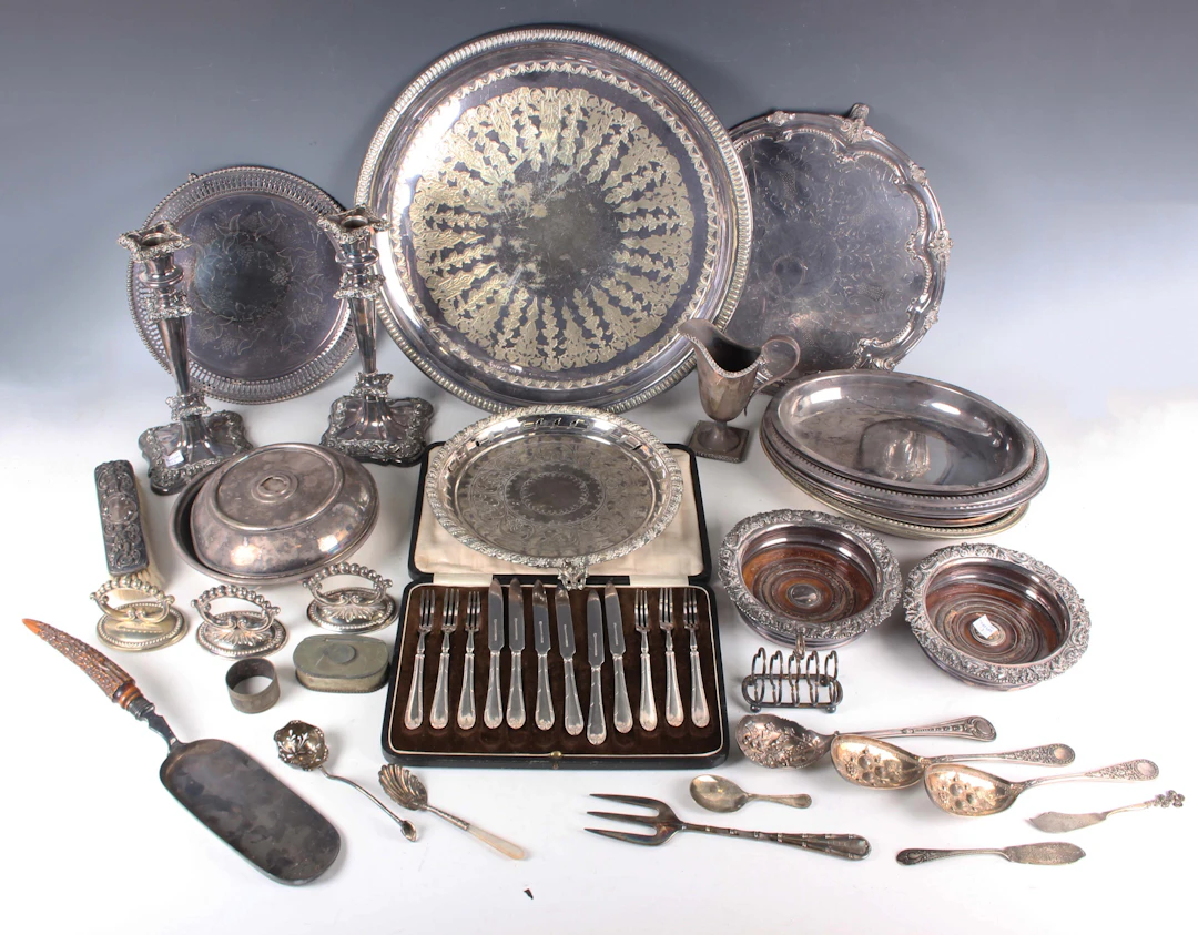 A group of plated items, including a pair of candlesticks, a pair