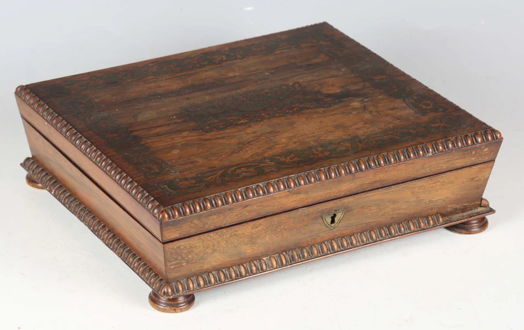 A Regency rosewood and brass inlaid workbox with bead and reel moulded