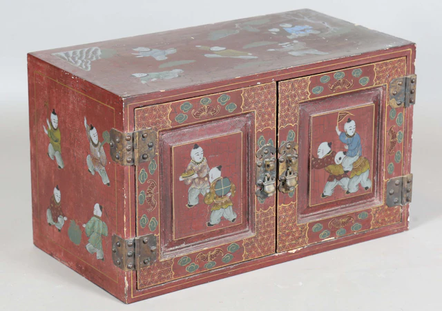 A small Chinese lacquered two-door cabinet, painted with overall figures