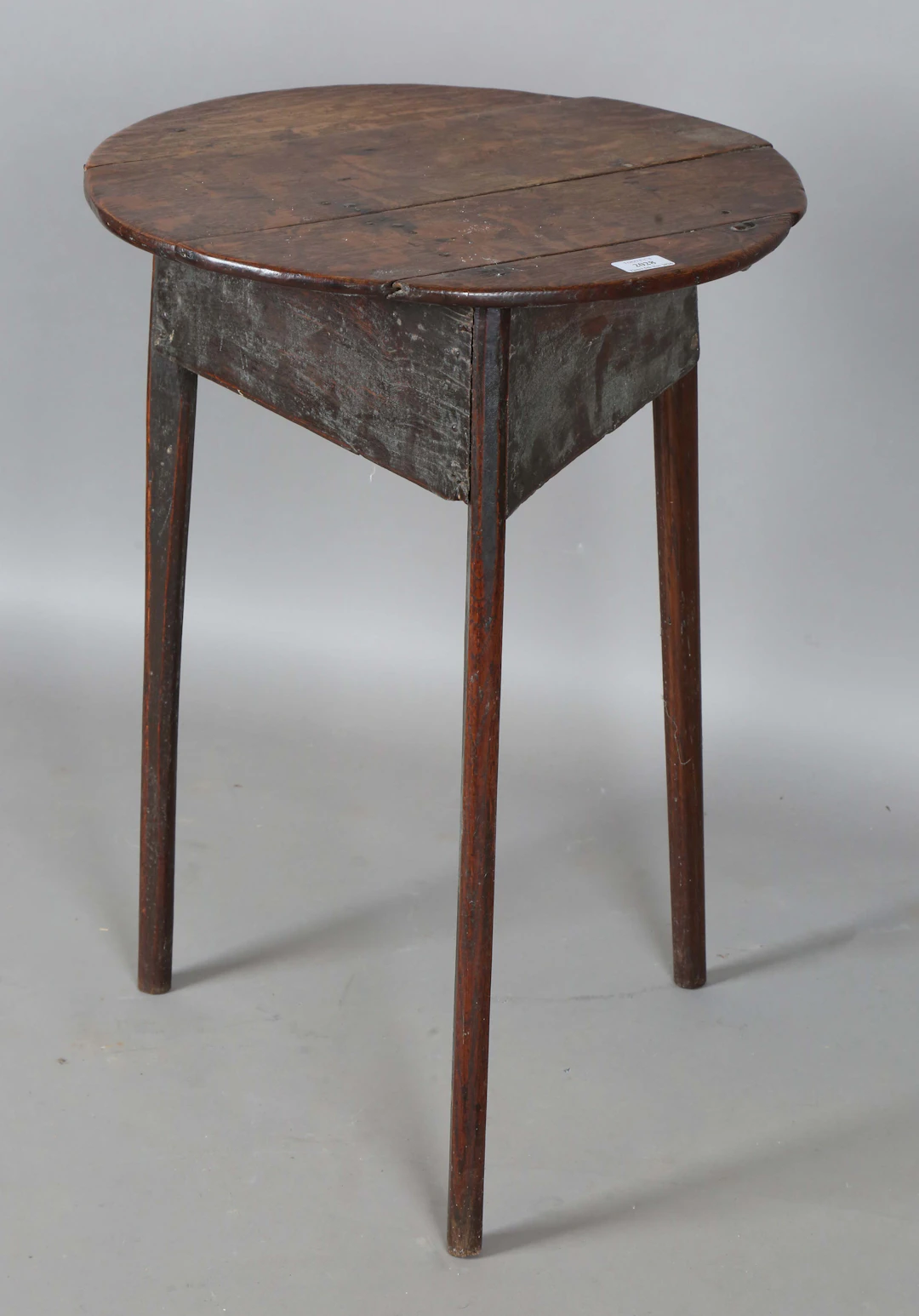 An 18th century provincial oak cricket table, the circular top above