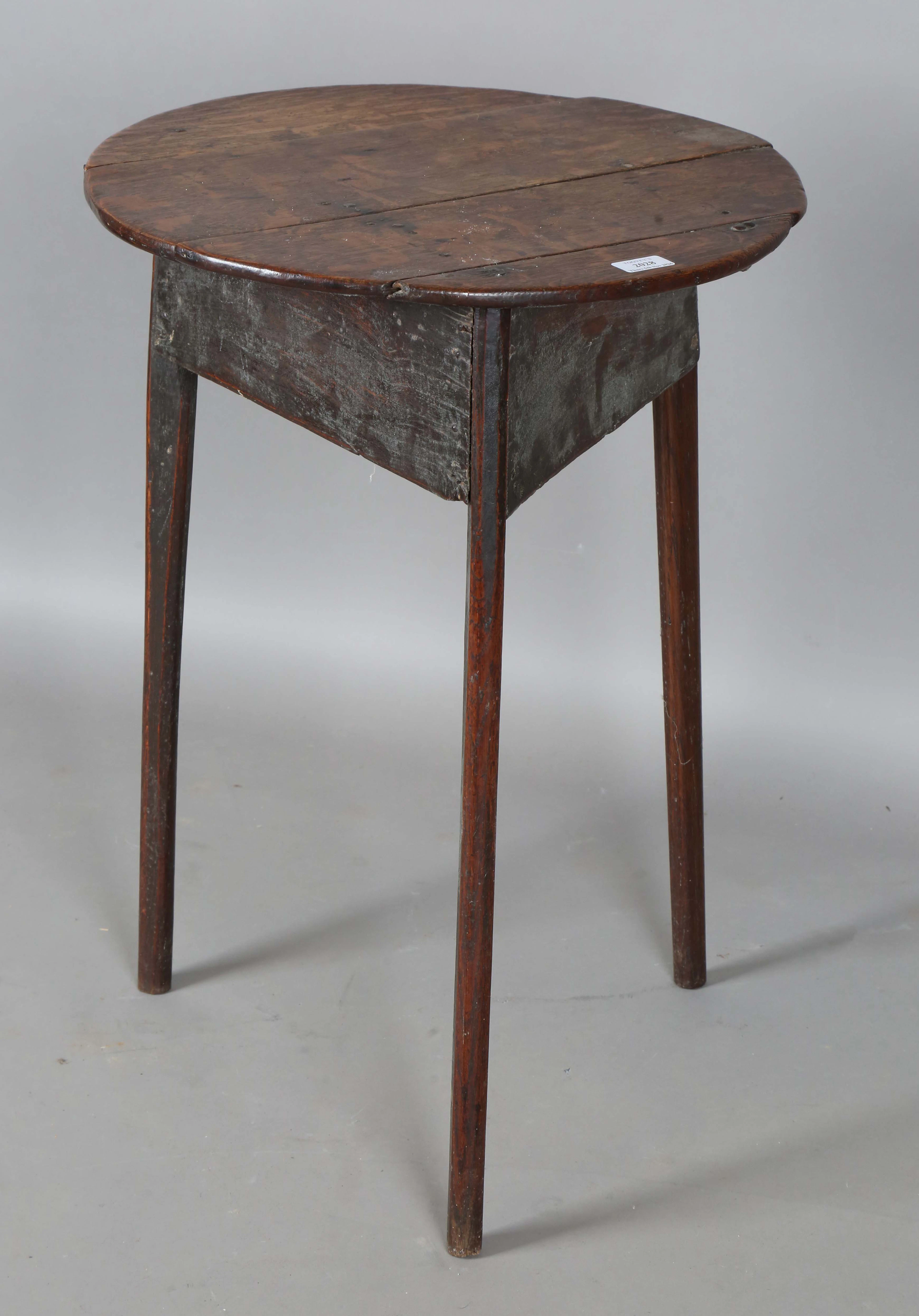 An 18th century provincial oak cricket table, the circular top above
