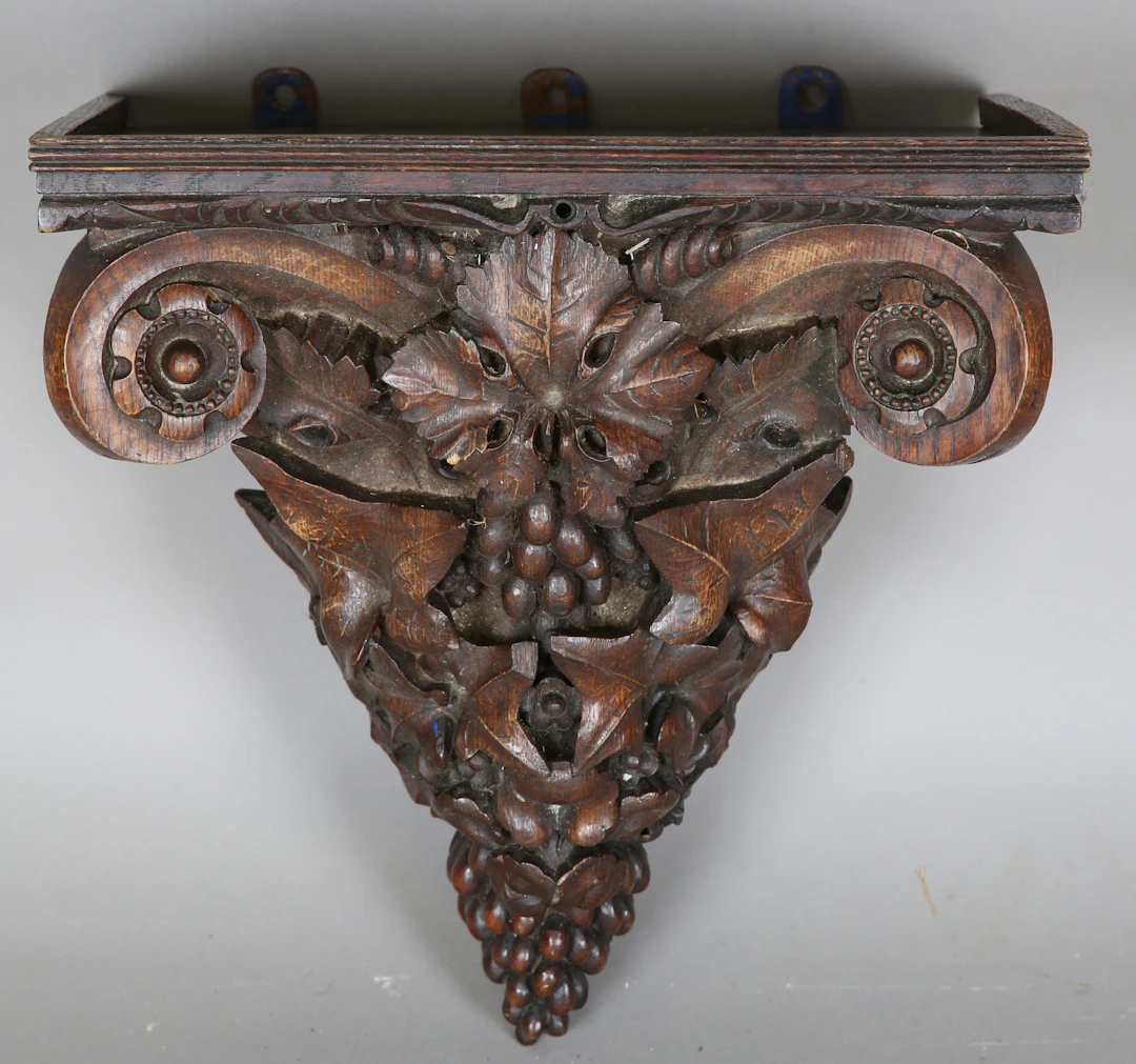 A late Victorian oak wall bracket, finely carved with scrolls, vine
