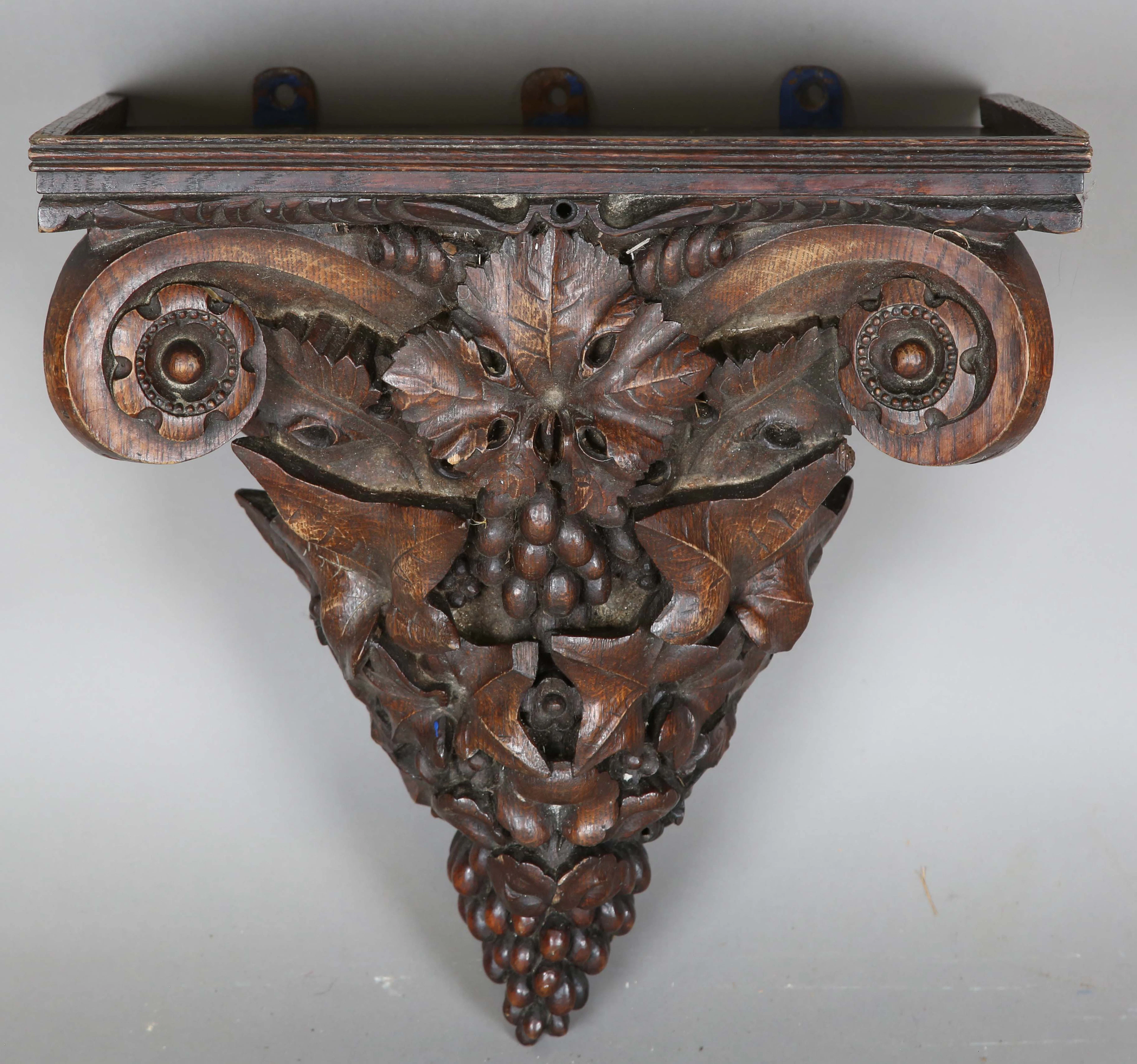 A late Victorian oak wall bracket, finely carved with scrolls, vine