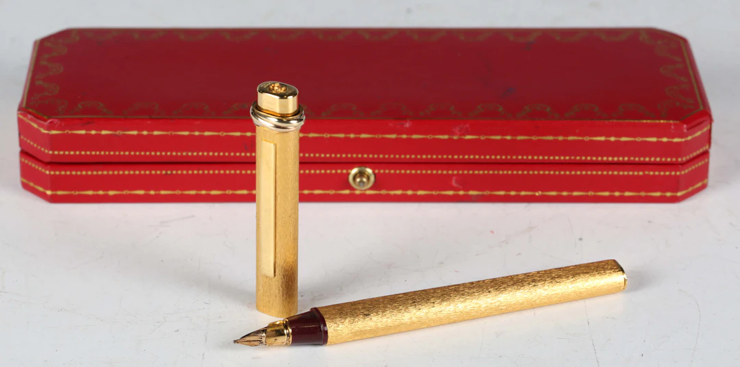 A Must de Cartier gilt metal cased fountain pen, within a fitted case