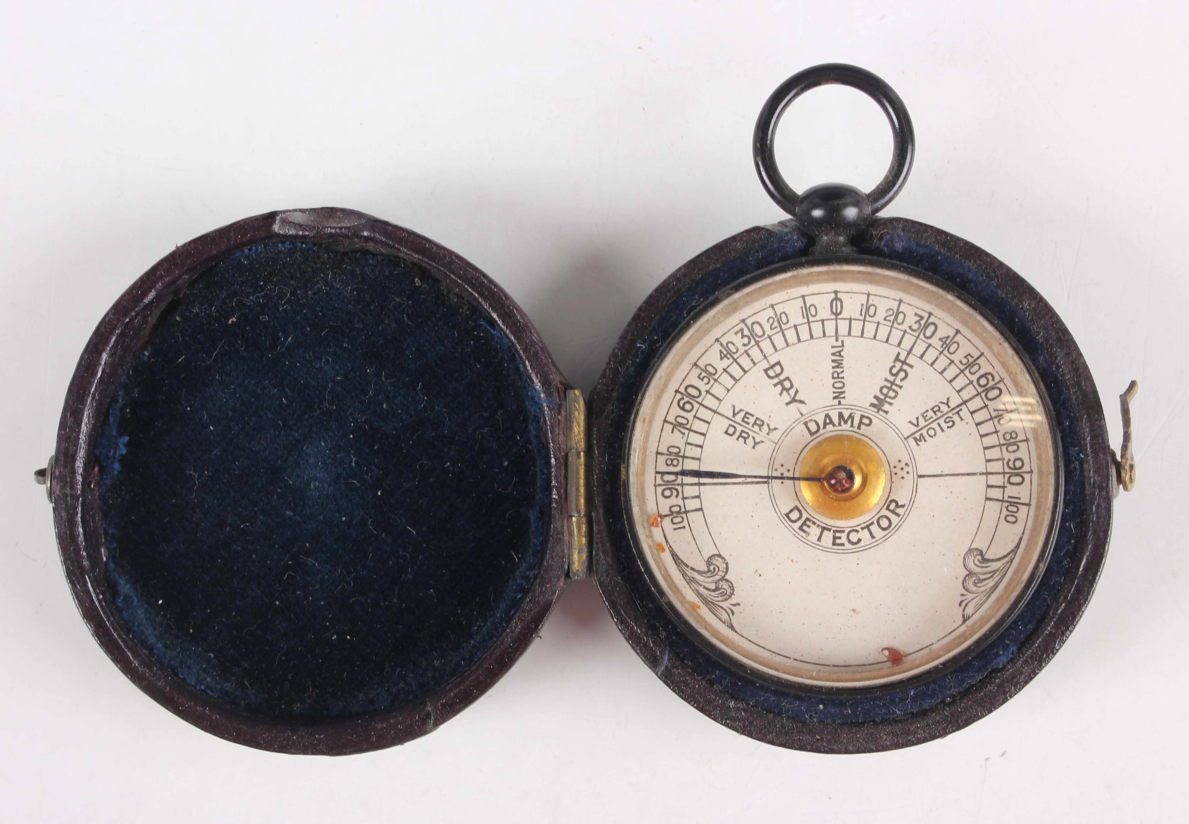 An early 20th century black enamelled circular cased damp detector