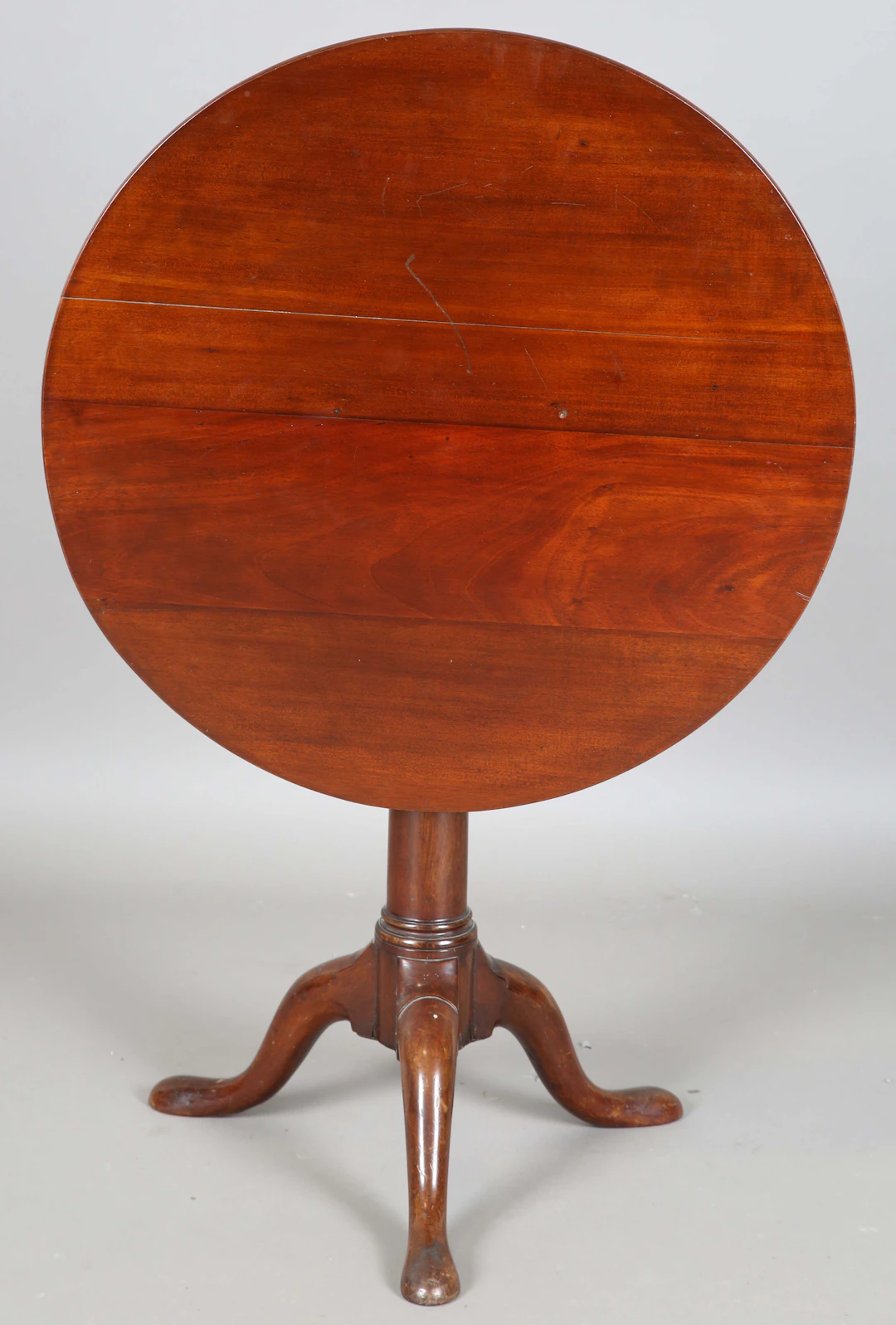 A George III mahogany circular tip-top supper table, raised on a turned
