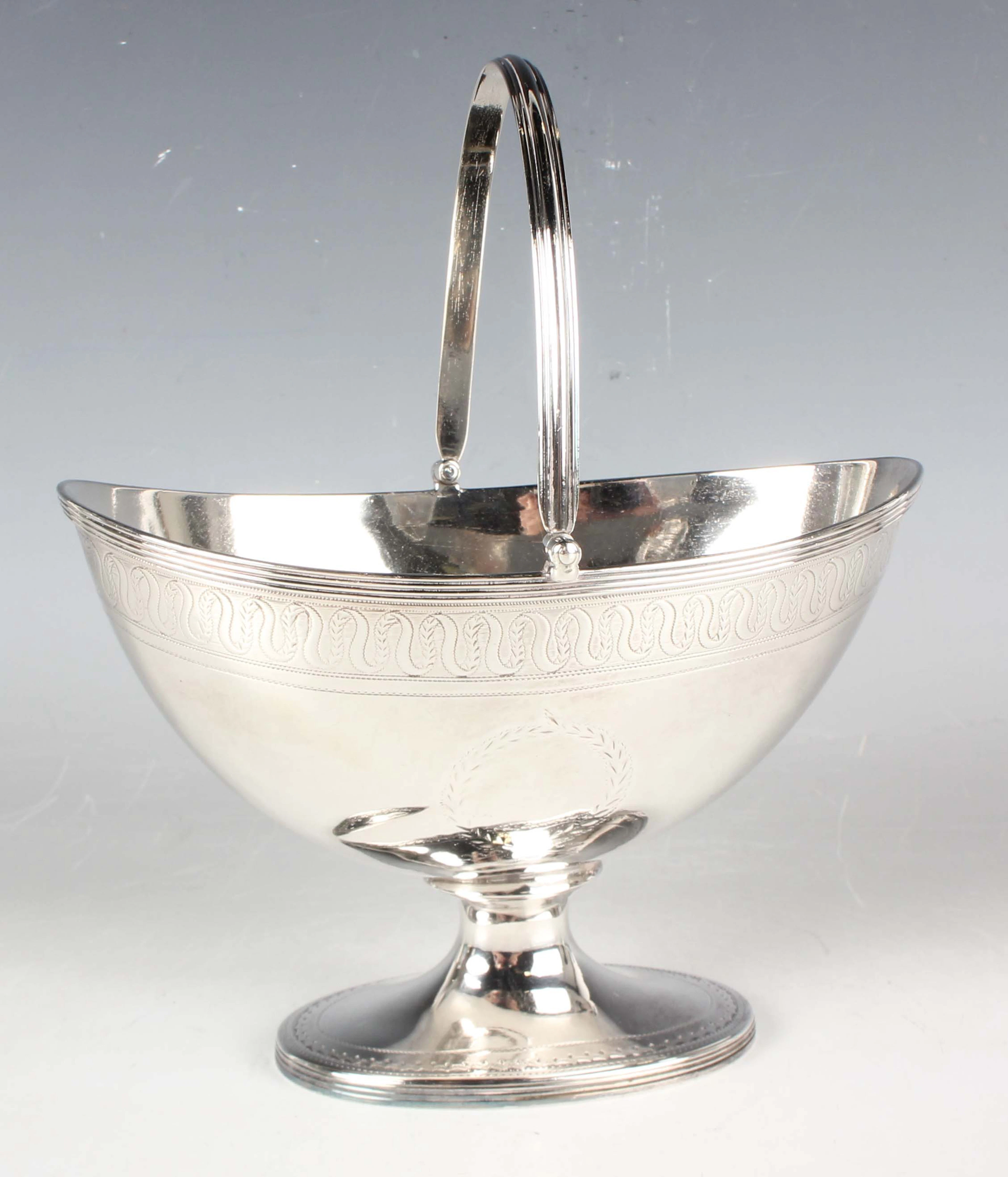 A George III silver sugar basket of oval form with reeded swing handle