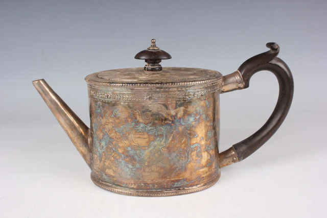 A George IV silver oval teapot, later engraved with foliate scrolls