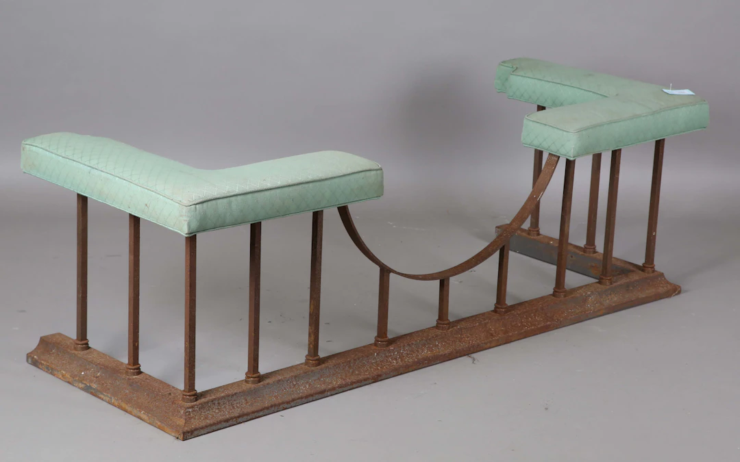 A 20th century steel framed club fender, the upholstered seat raised