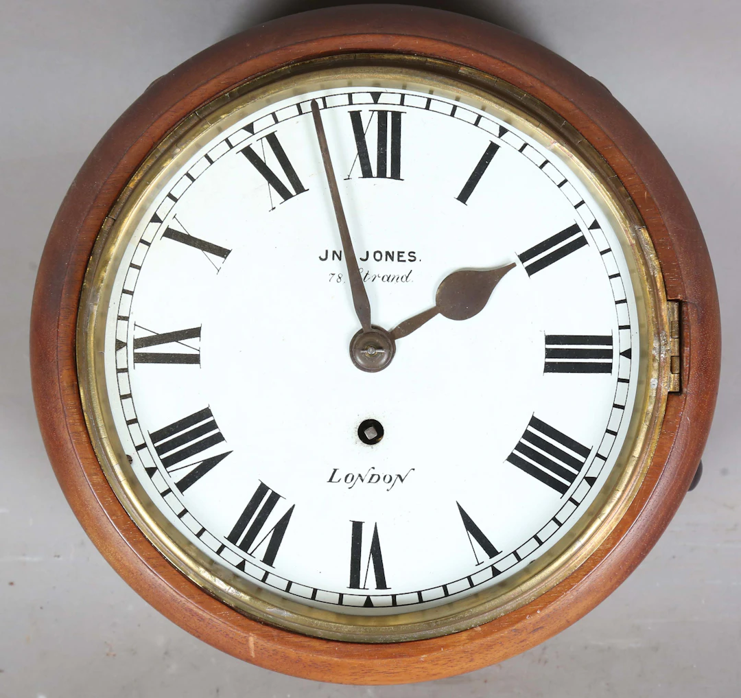 An early 20th century mahogany circular wall timepiece with brass