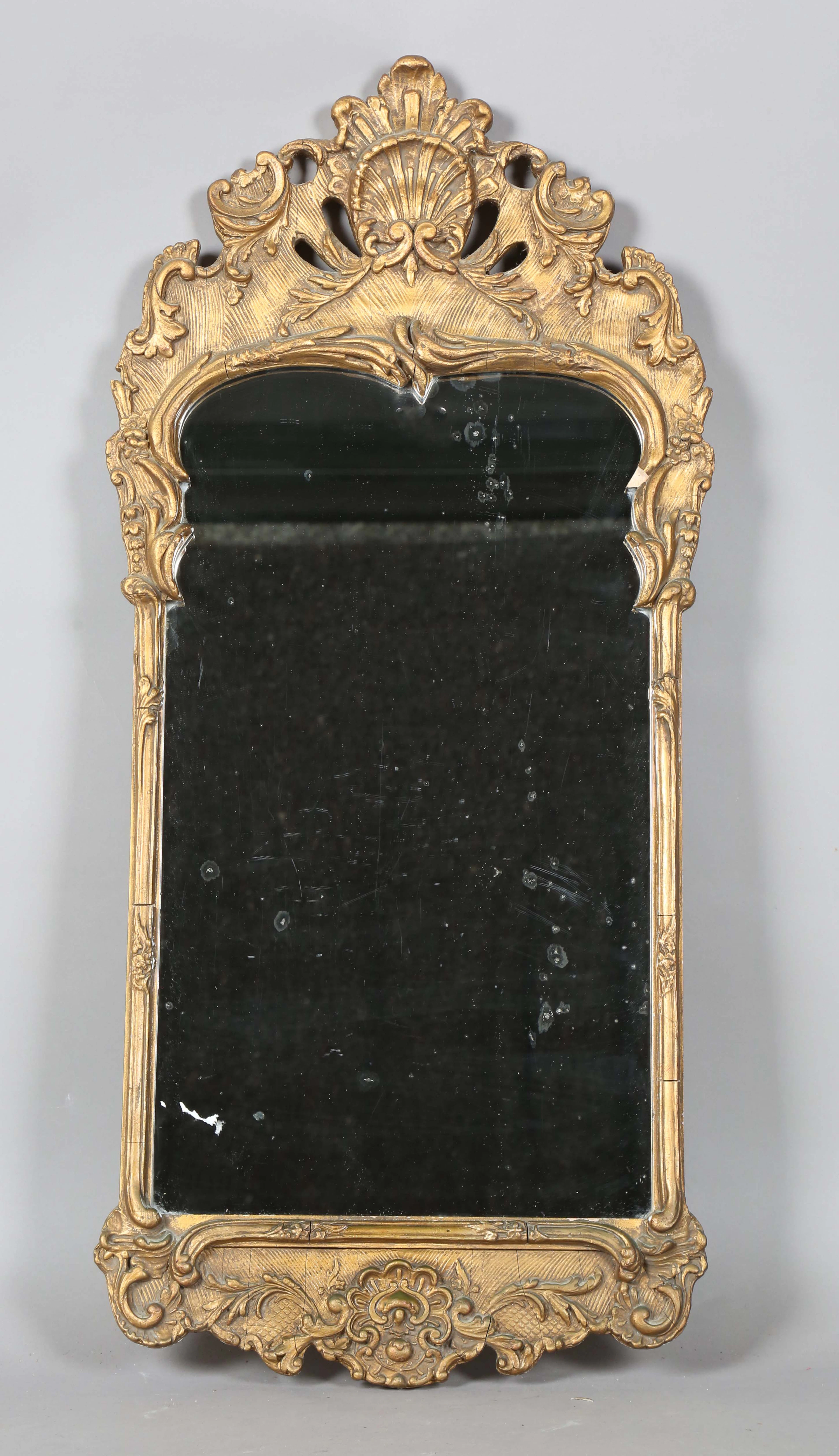 A 20th century Rococo style gilt composition wall mirror, the frame