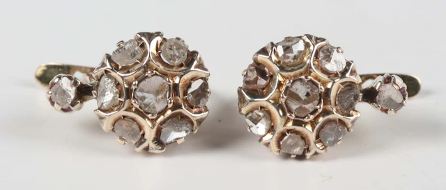 A pair of yellow metal and rose cut diamond seven stone cluster earrings