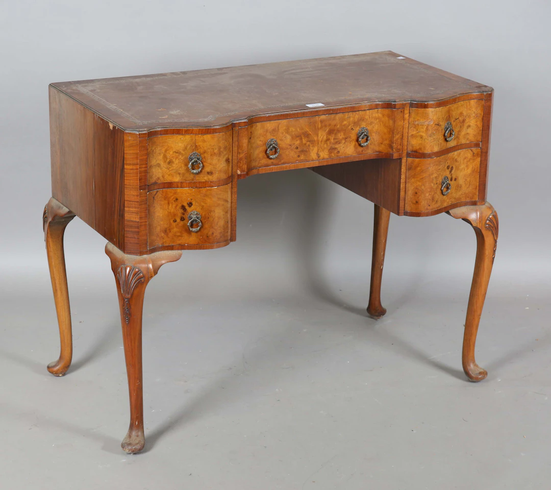 An early 20th century Queen Anne style burr walnut writing table
