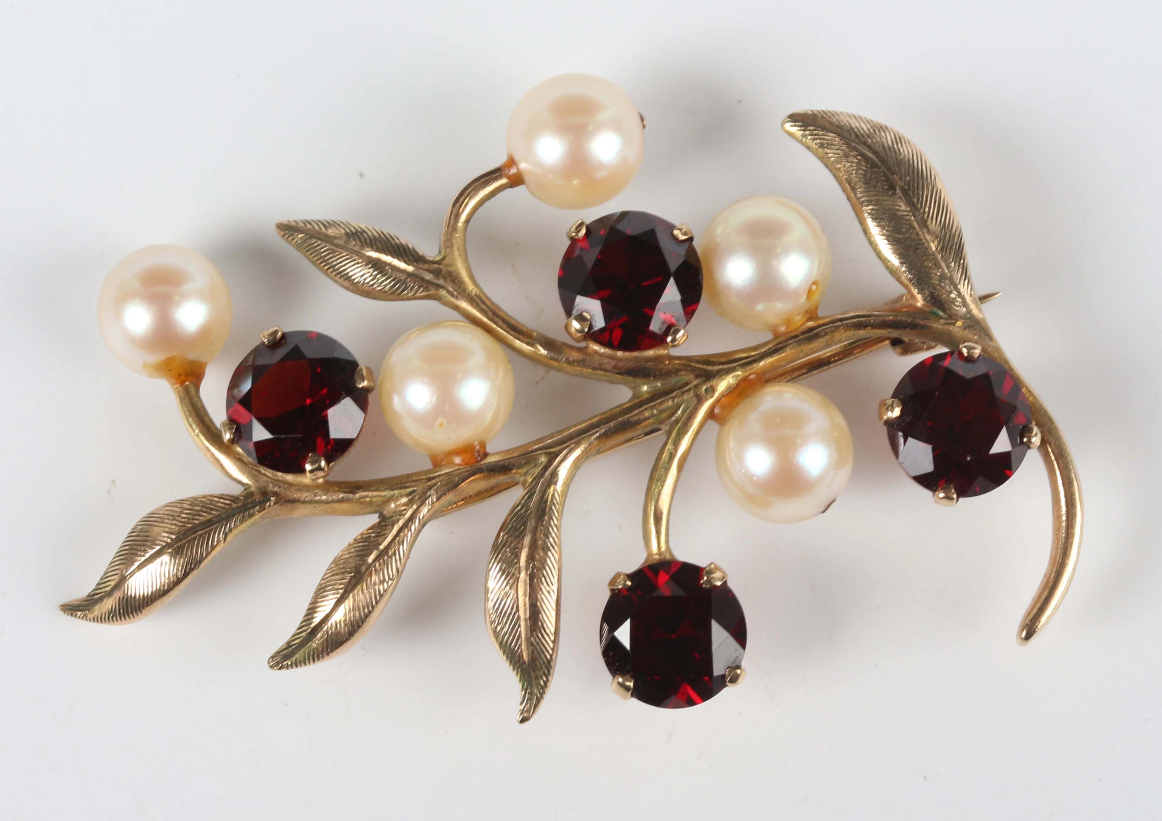 A 9ct gold, garnet and cultured pearl brooch in a foliate spray design