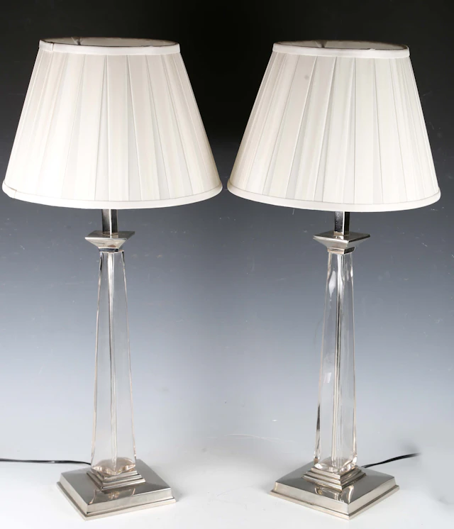 A pair of modern glass and plated metal table lamps with pleated fabric