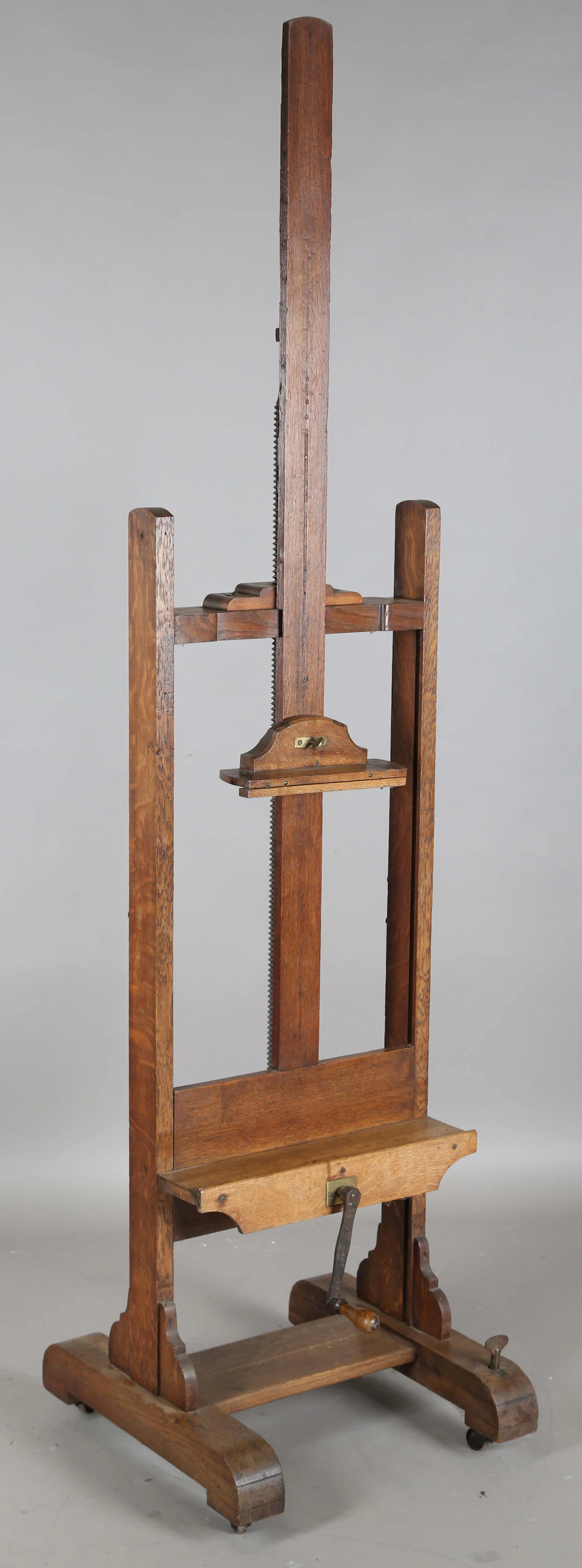 A late Victorian oak framed artist's easel with central winding screw