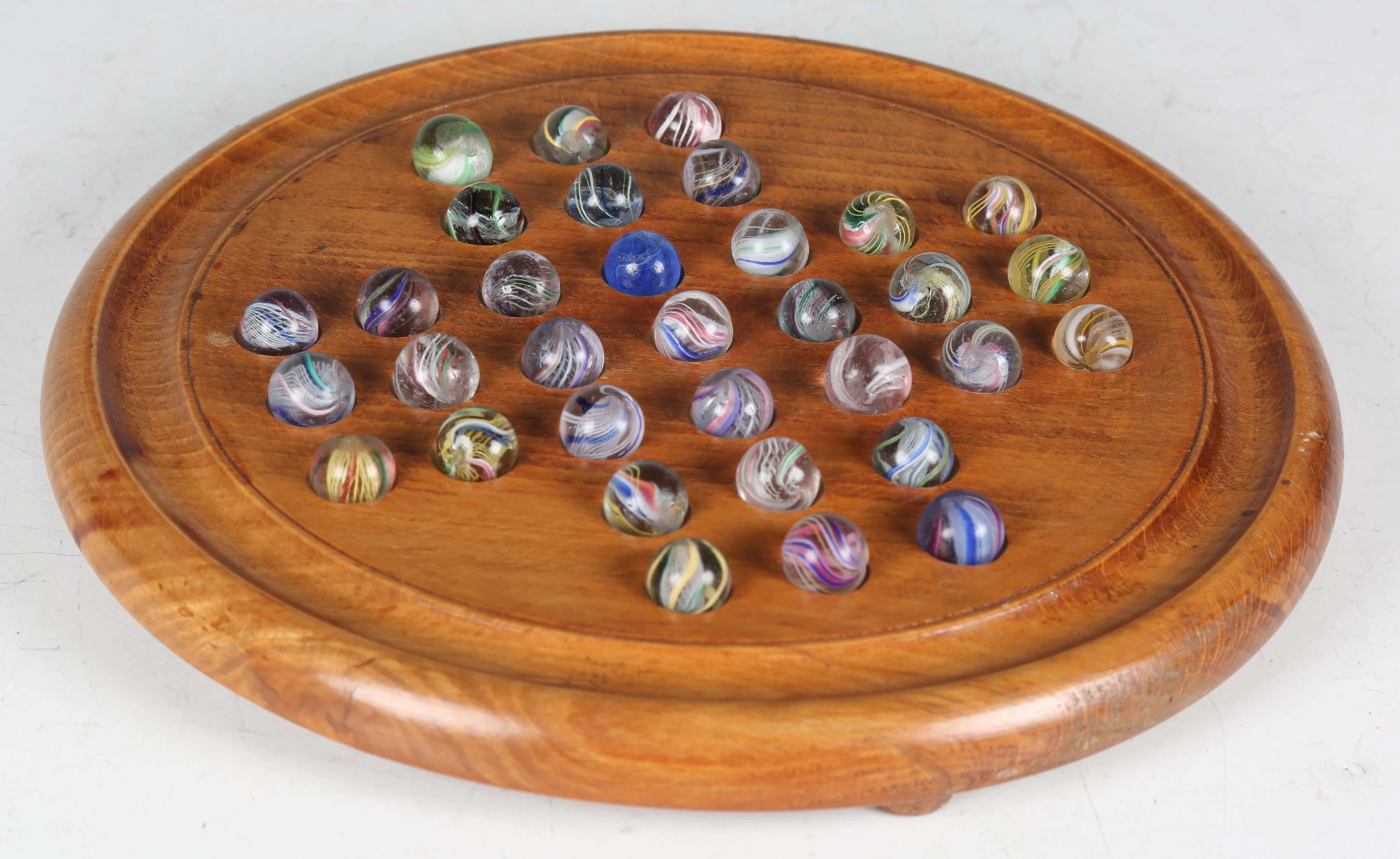 A 20th century beech solitaire board with thirty-three 19th century