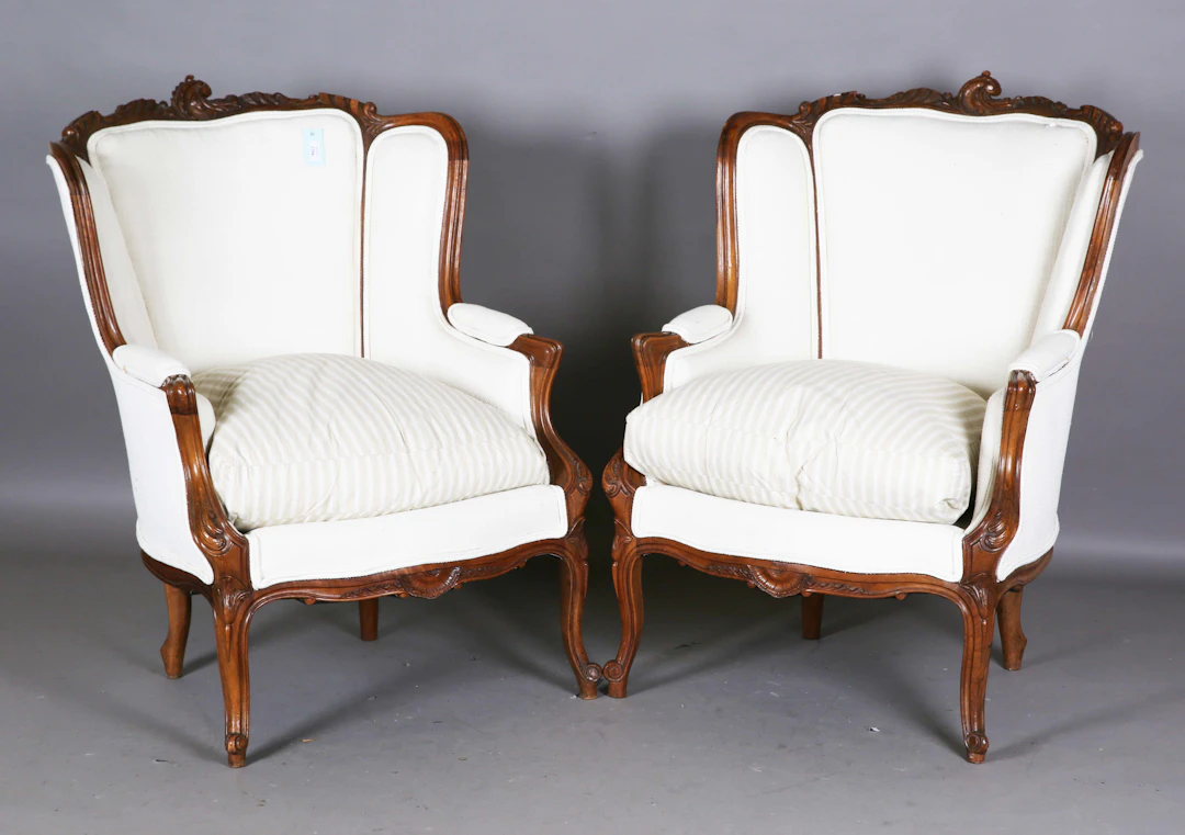 A pair of early 20th century French walnut showframe armchairs with
