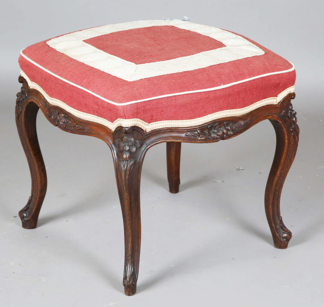 A mid-Victorian rosewood stool, the overstuffed seat on finely carved