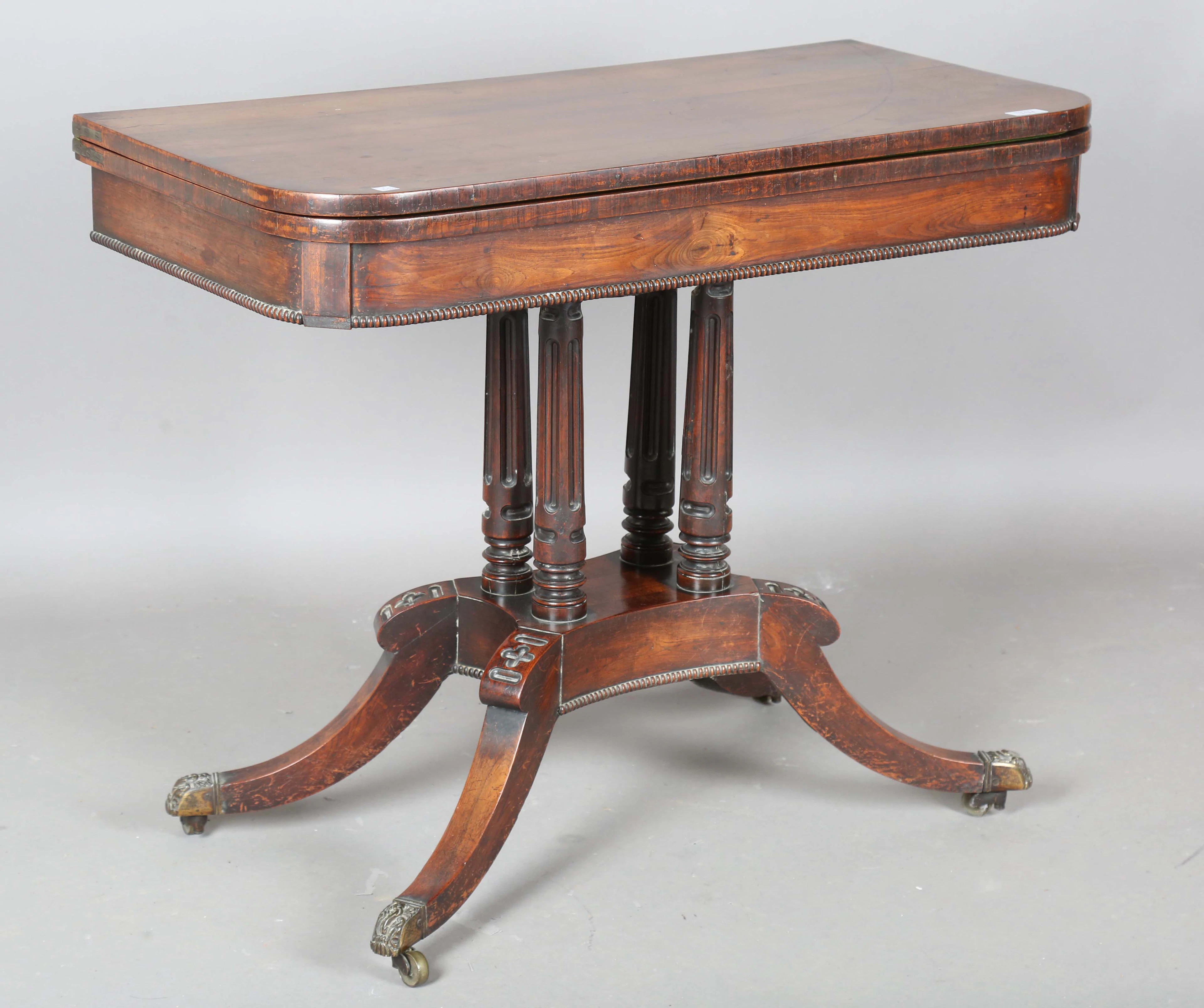 A Regency gonçalo alves fold-over card table, raised on four fluted