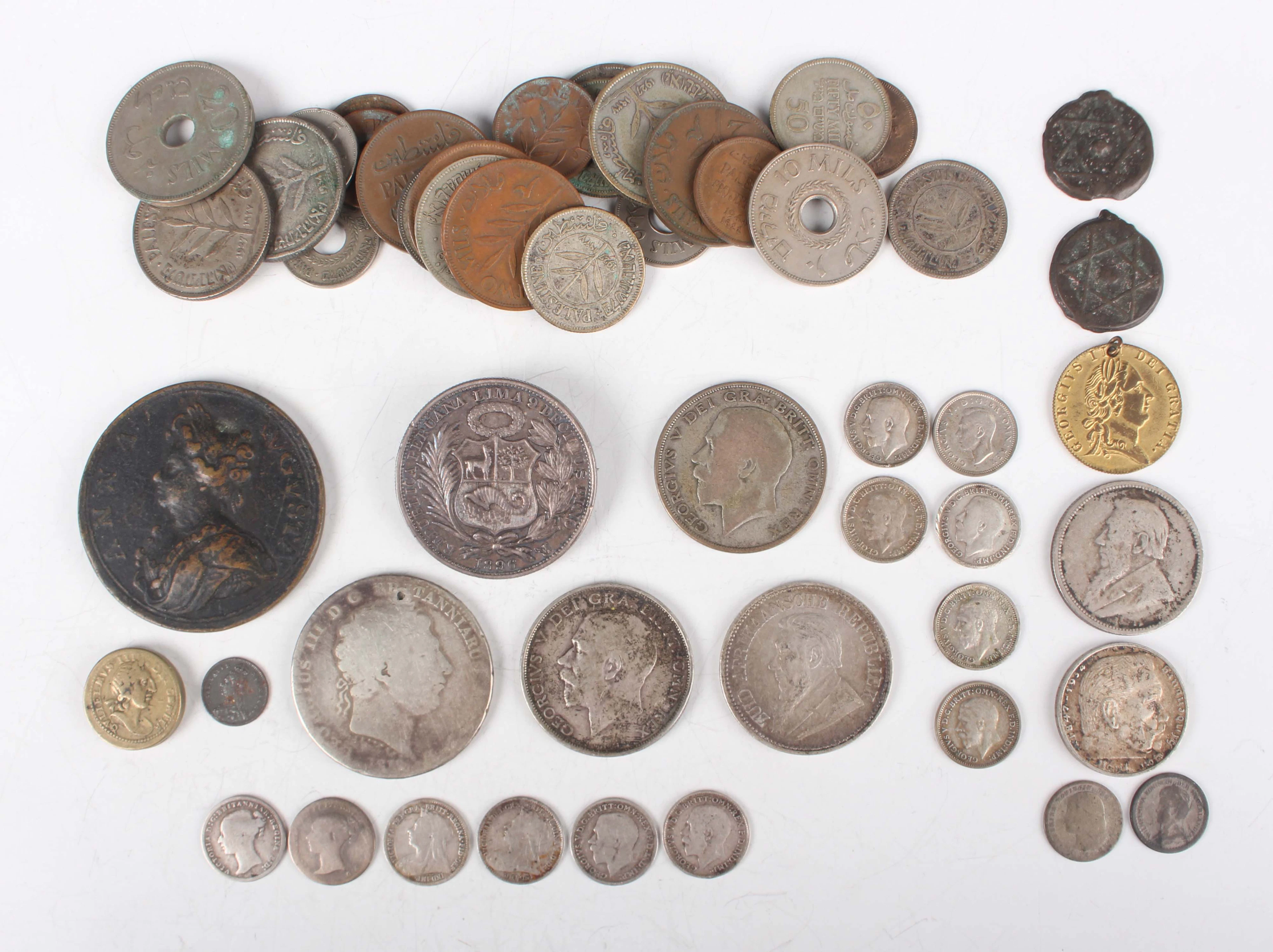 A collection of mixed world coins and paranumismatic items, including