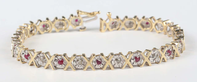 A 9ct two colour gold, ruby and diamond bracelet, mounted with alternating