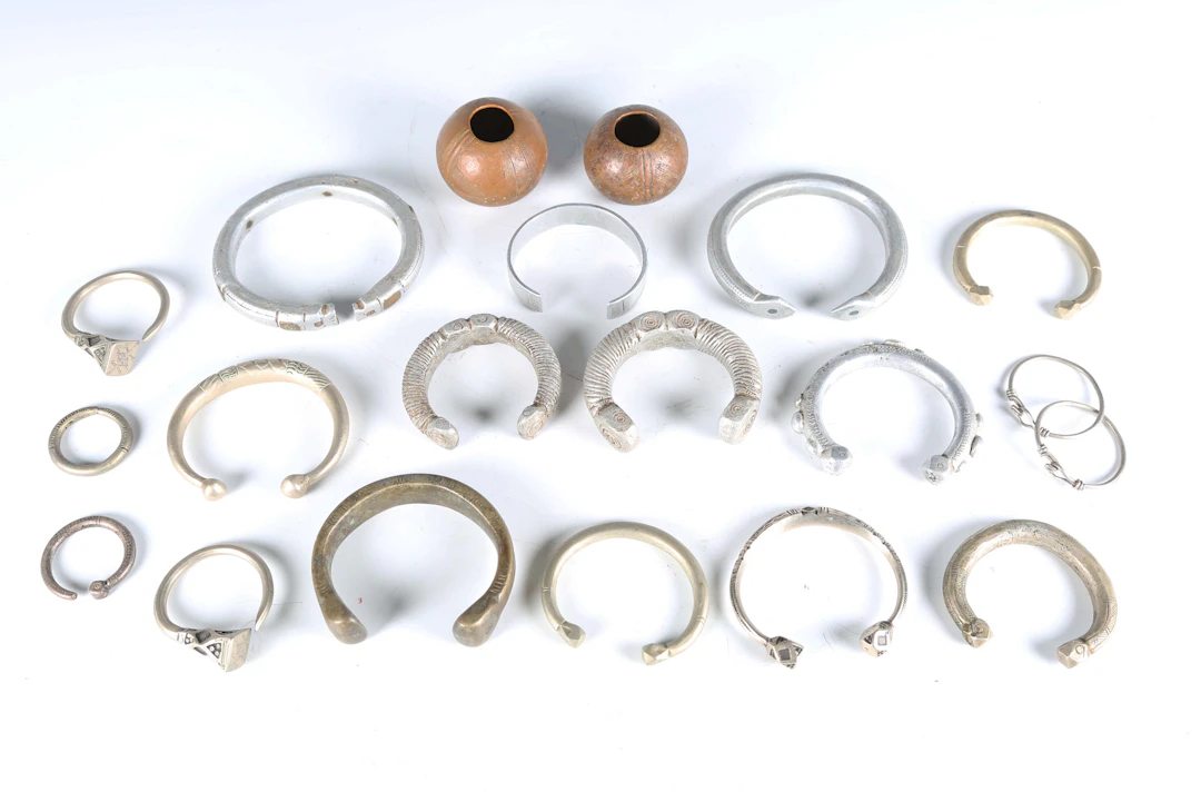 A collection of African manilla style currency bangles, including