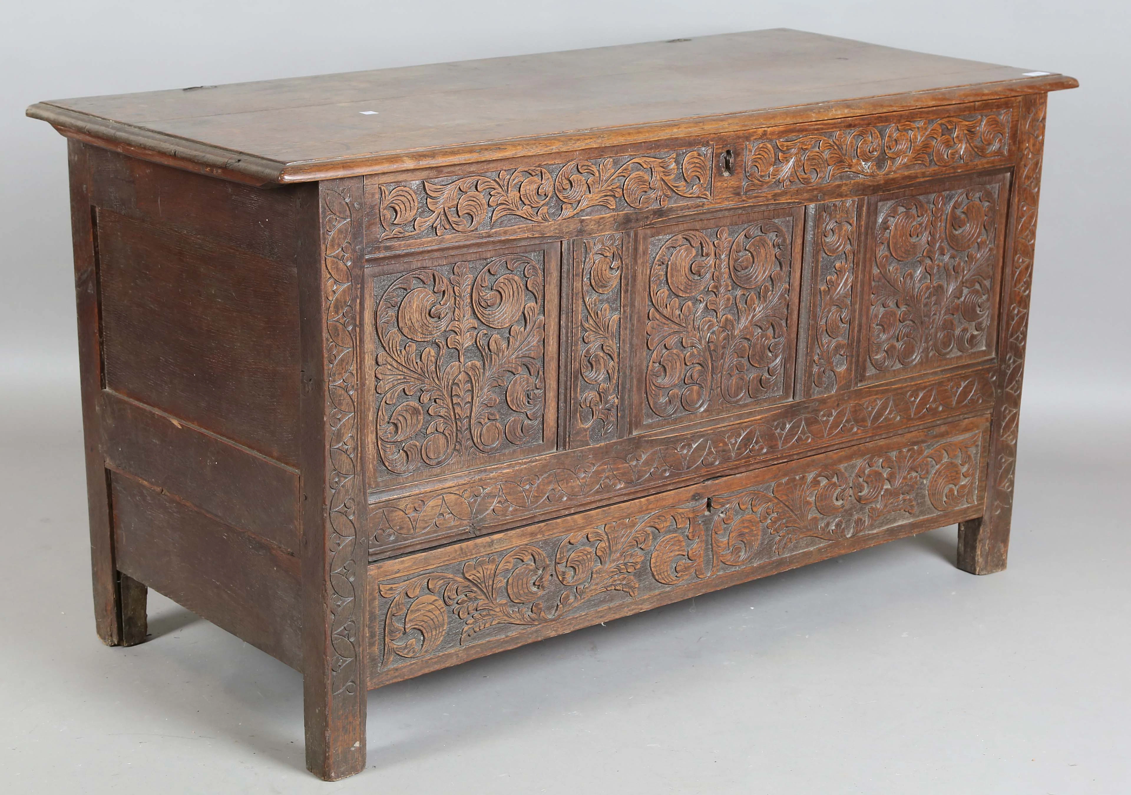 A late 17th/early 18th century oak panelled coffer with later carved