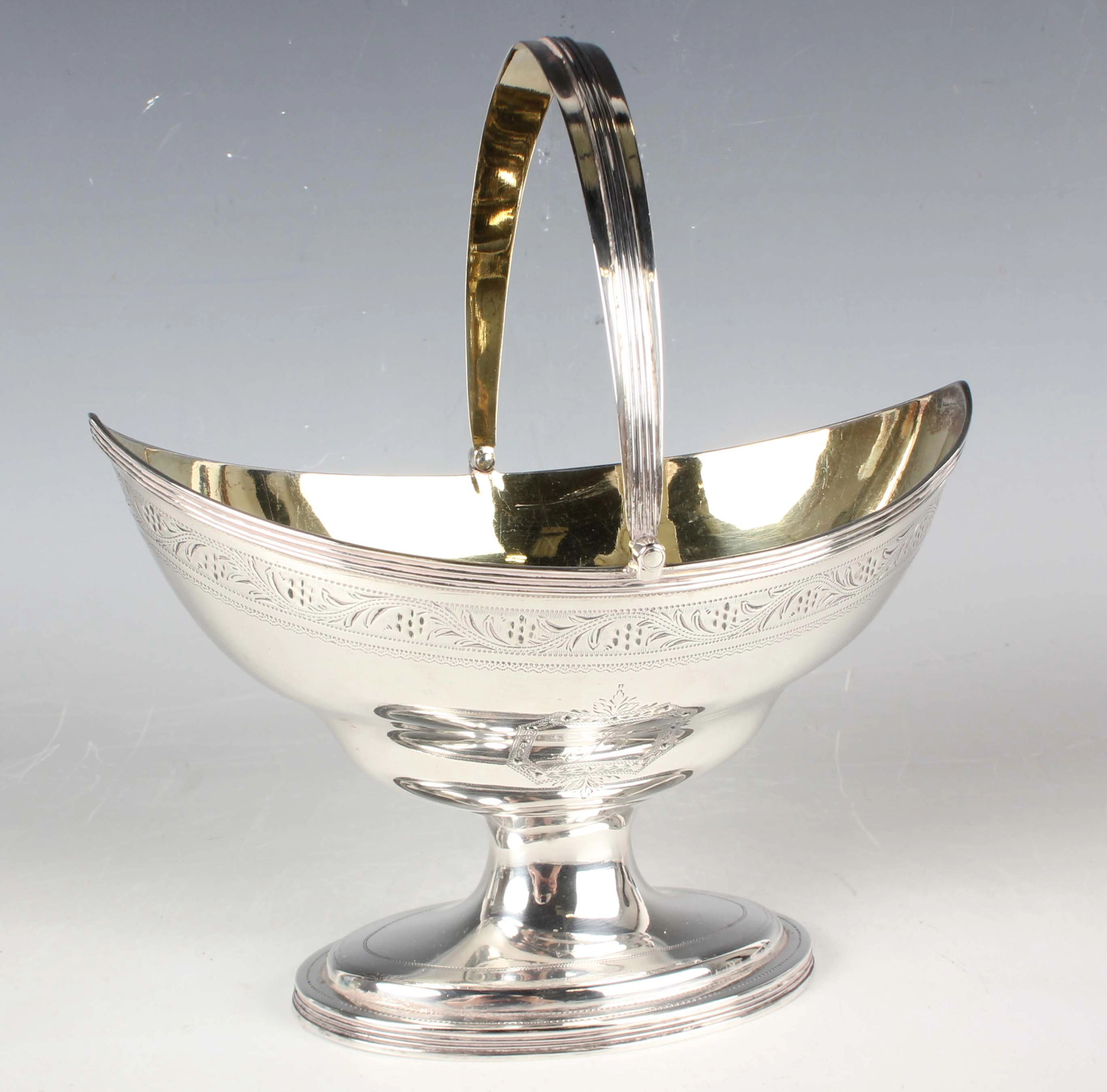 A George III silver sugar basket of oval ogee form with reeded swing