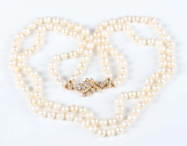 A two row necklace of cultured pearls on a gold and diamond clasp