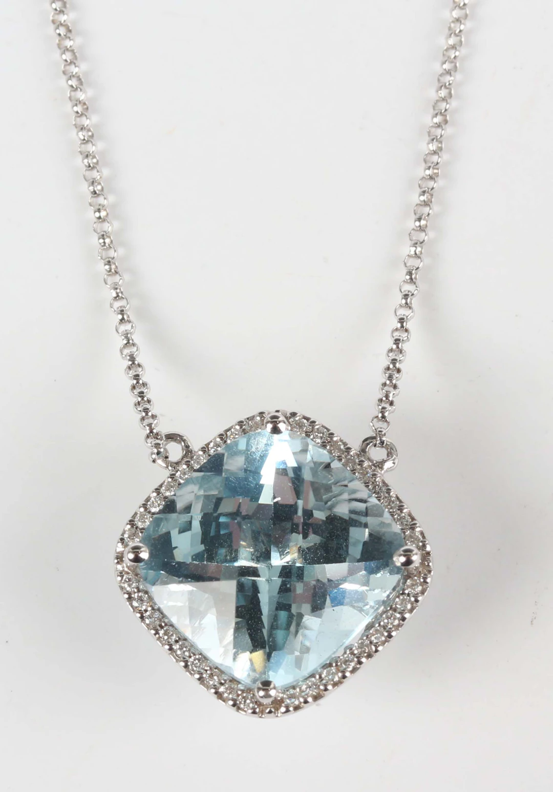 A white gold, blue topaz and diamond pendant necklace, mounted with