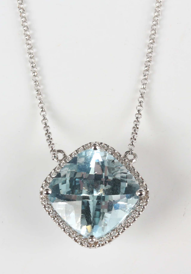 A white gold, blue topaz and diamond pendant necklace, mounted with