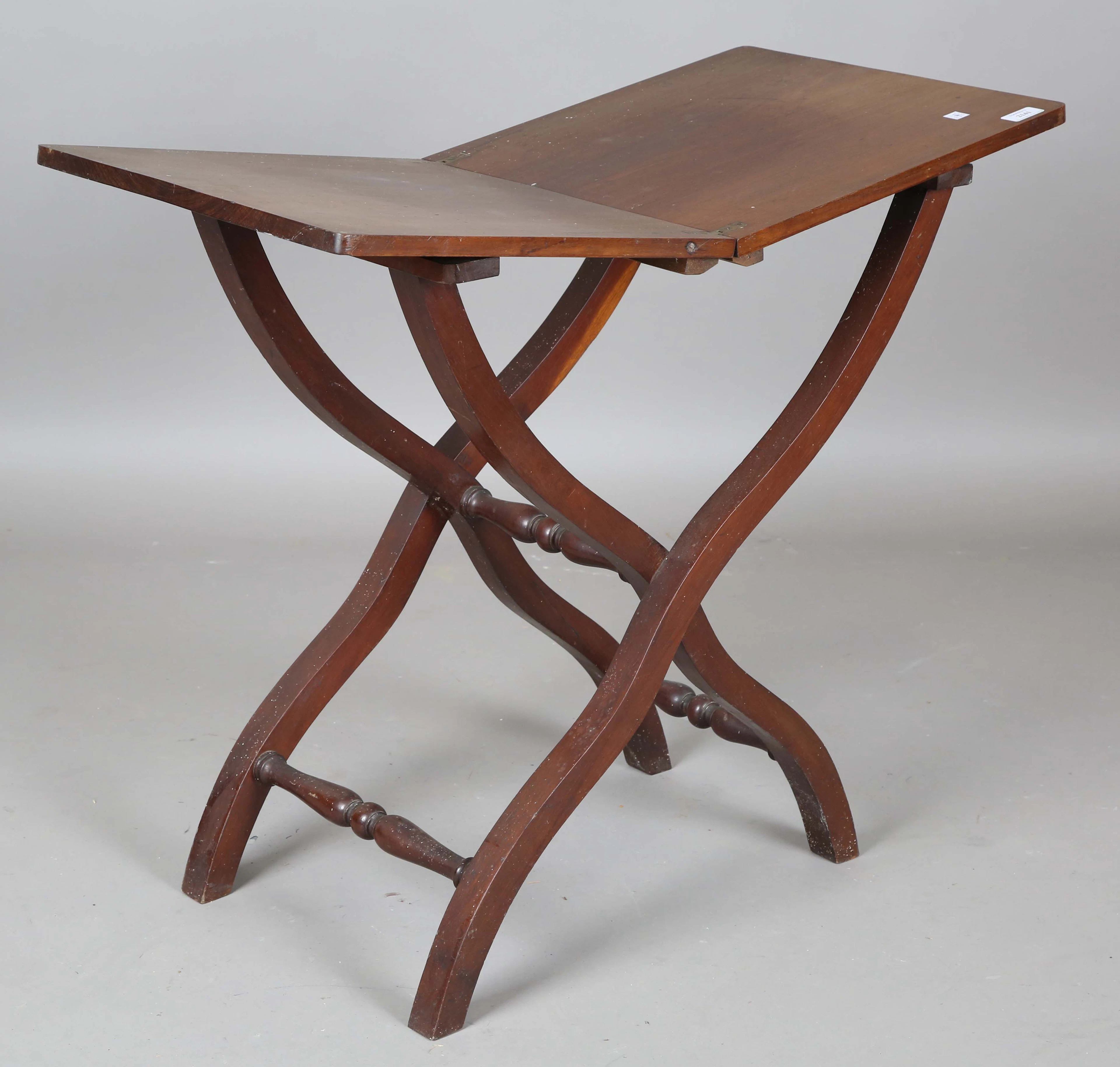 An early Victorian mahogany coaching table with folding ‘X’ frame