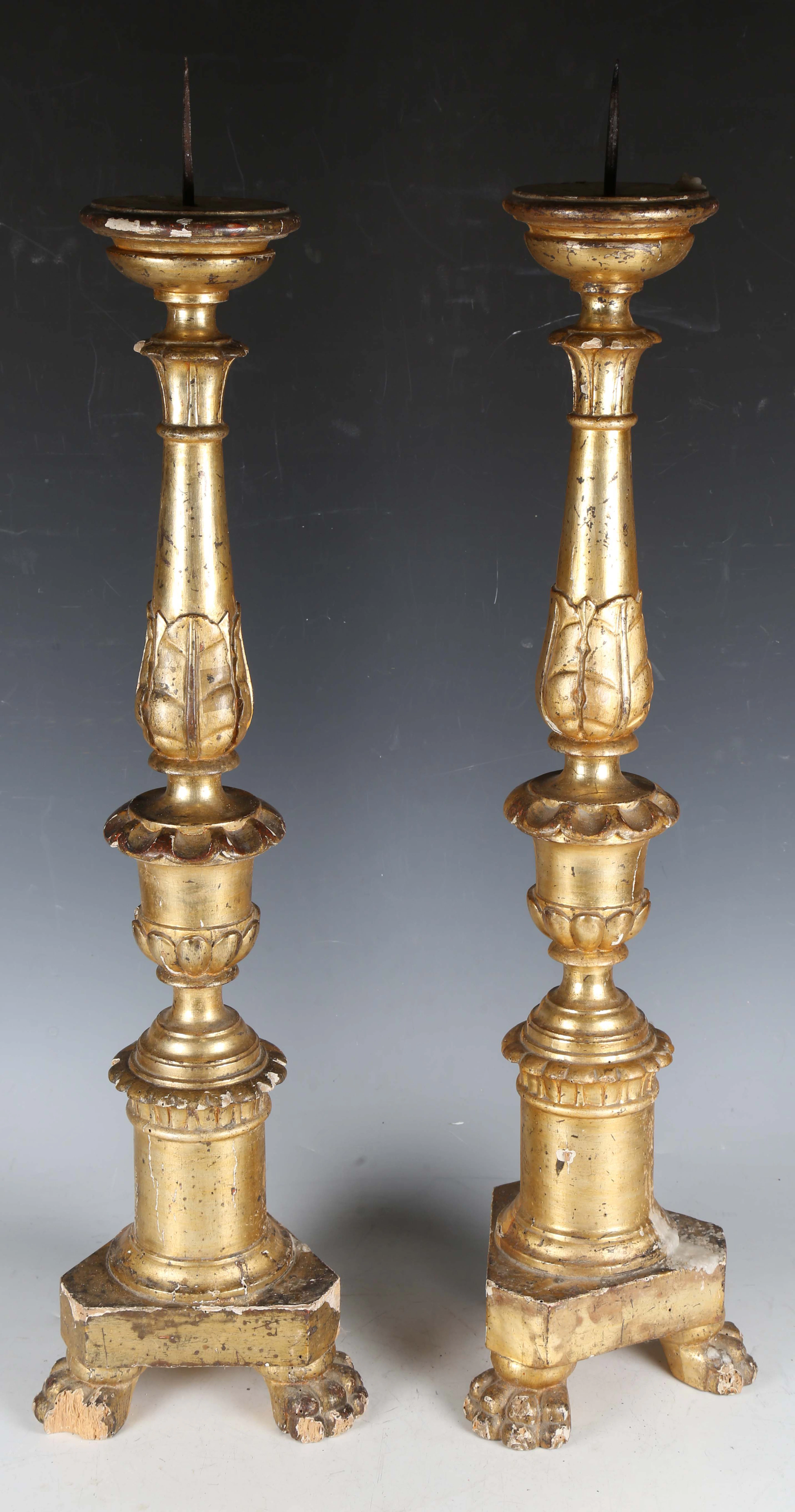 A pair of 19th century Italian giltwood pricket candle stands of carved