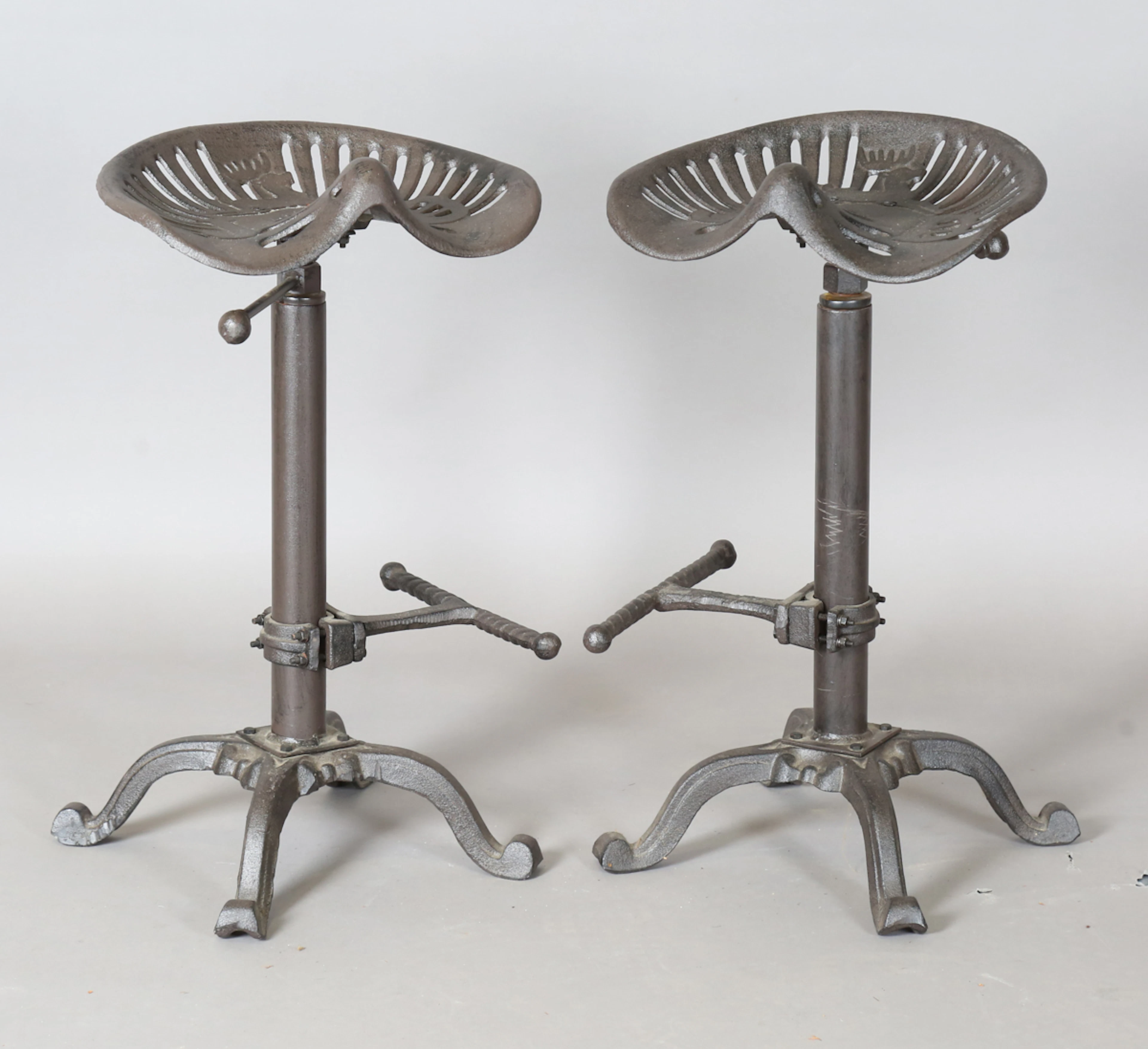 A pair of late 20th century cast iron bar stools with reproduction
