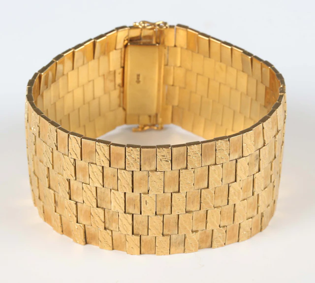 A gold wide textured link bracelet on a snap clasp, detailed ‘750’