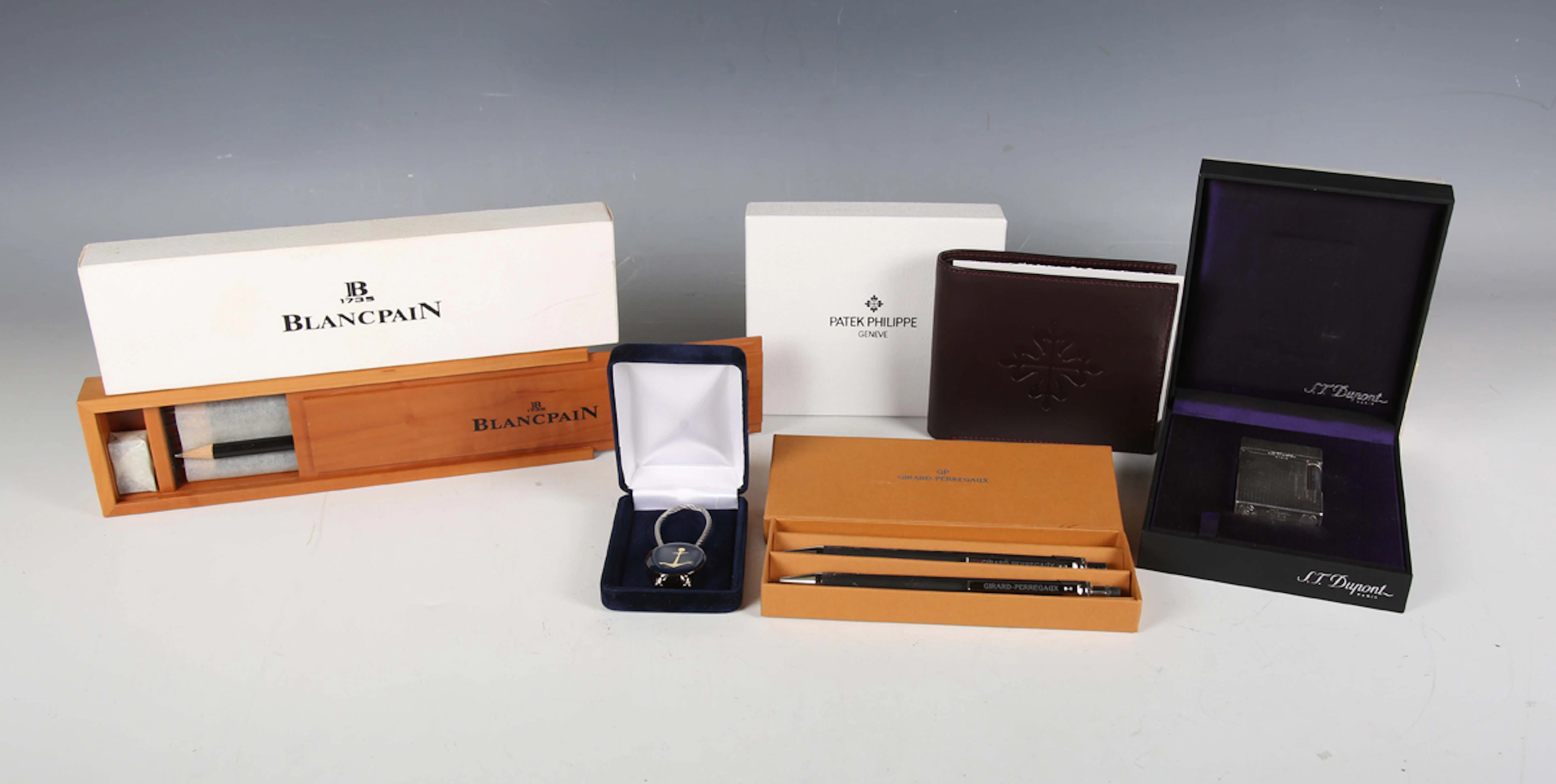 A group of luxury brand items, including an S.T. Dupont pocket lighter
