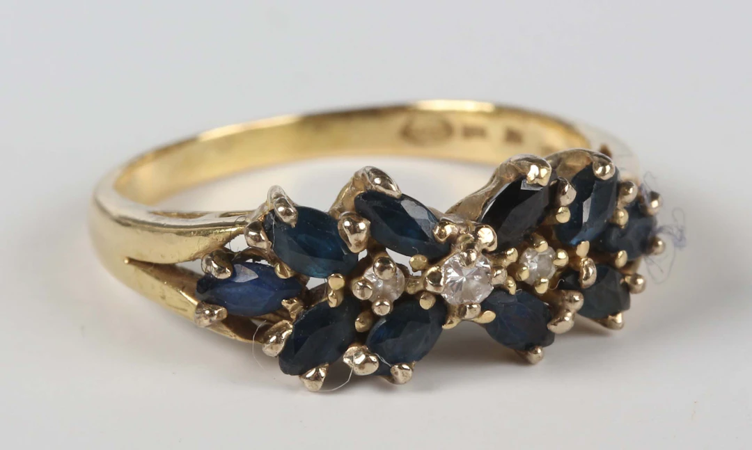 A gold, sapphire and diamond ring, mounted with a row of three graduated