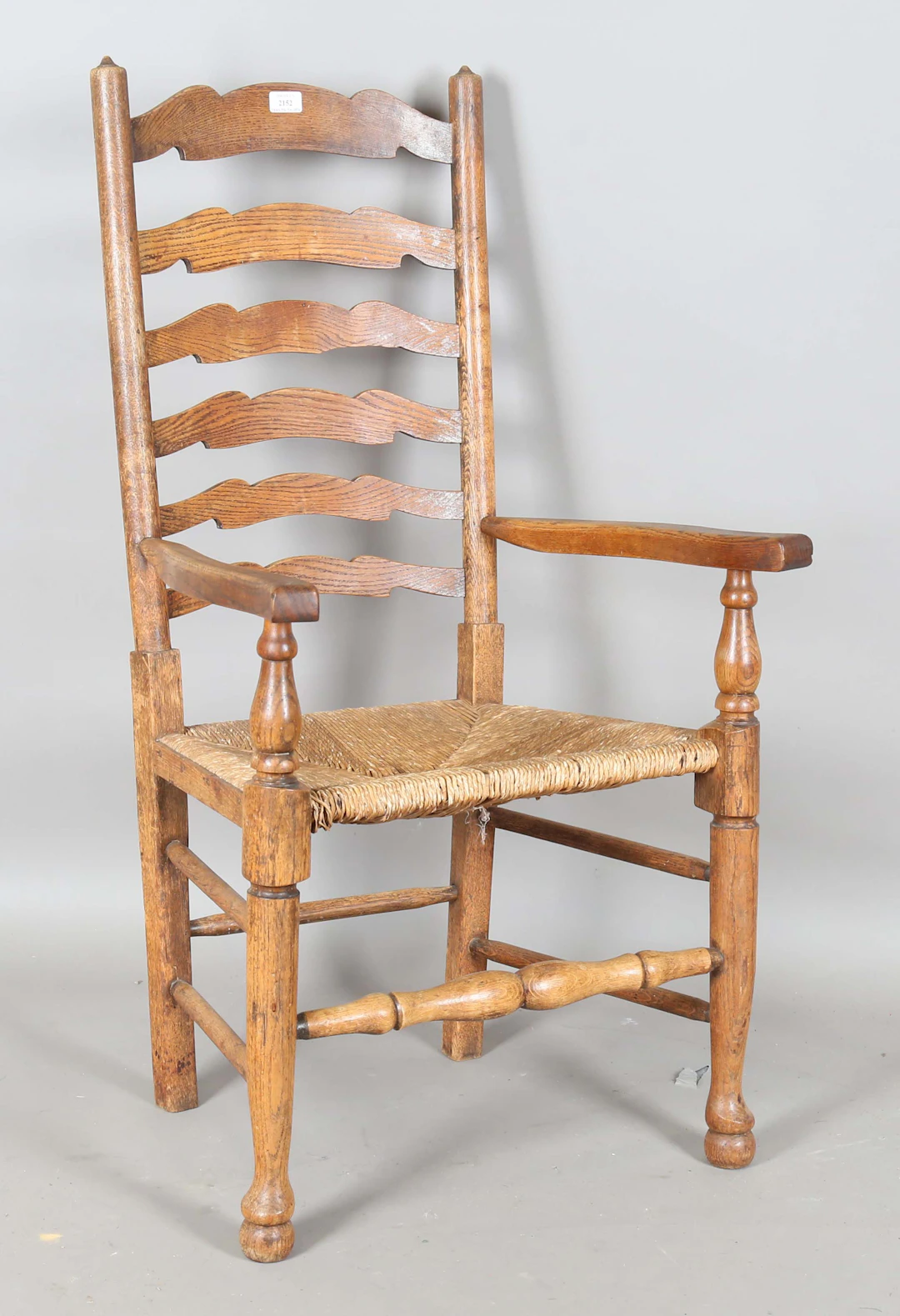 A mid-19th century provincial ash ladder back elbow chair with a rush