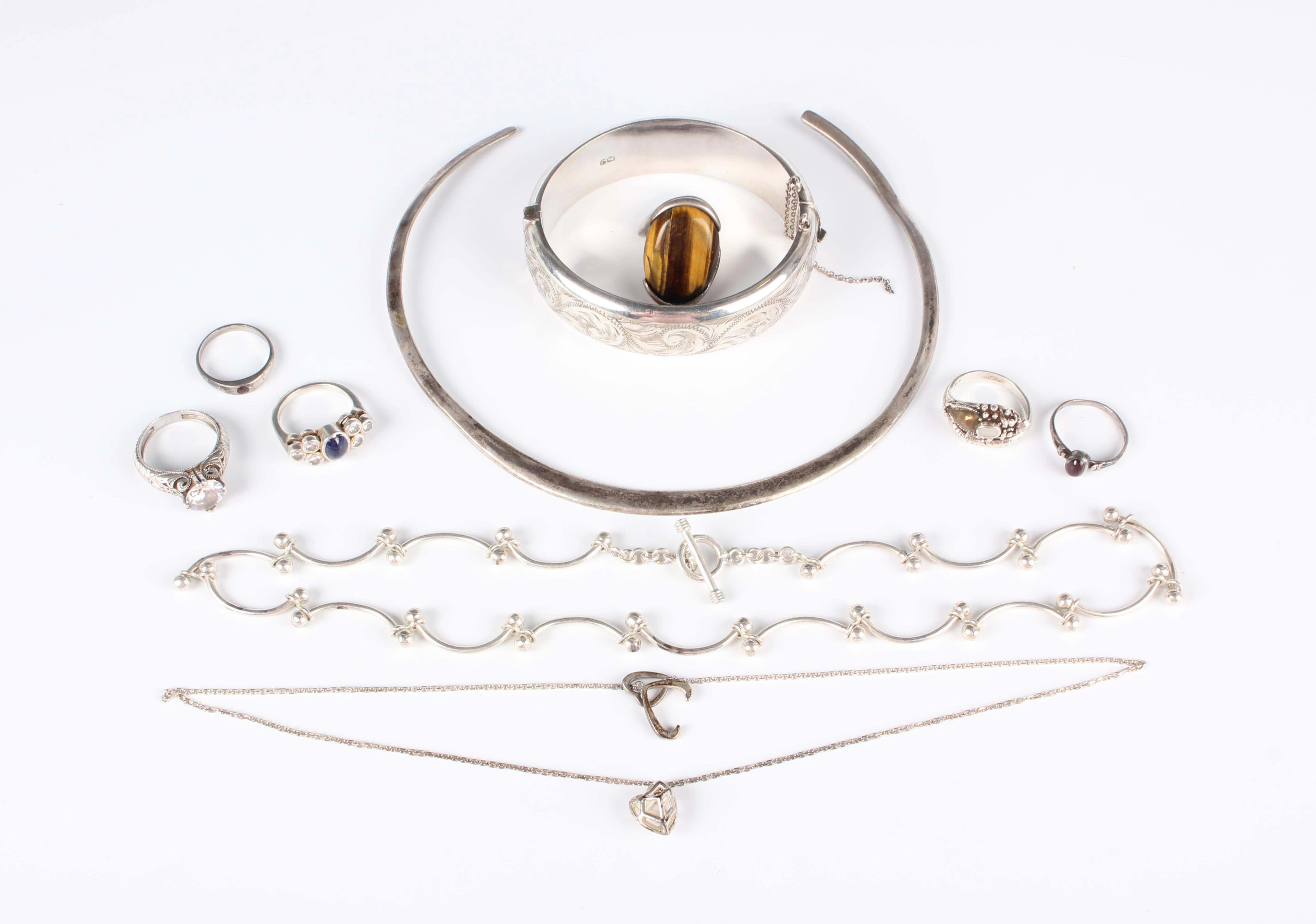 A group of silver jewellery, comprising an oval hinged bangle, inside