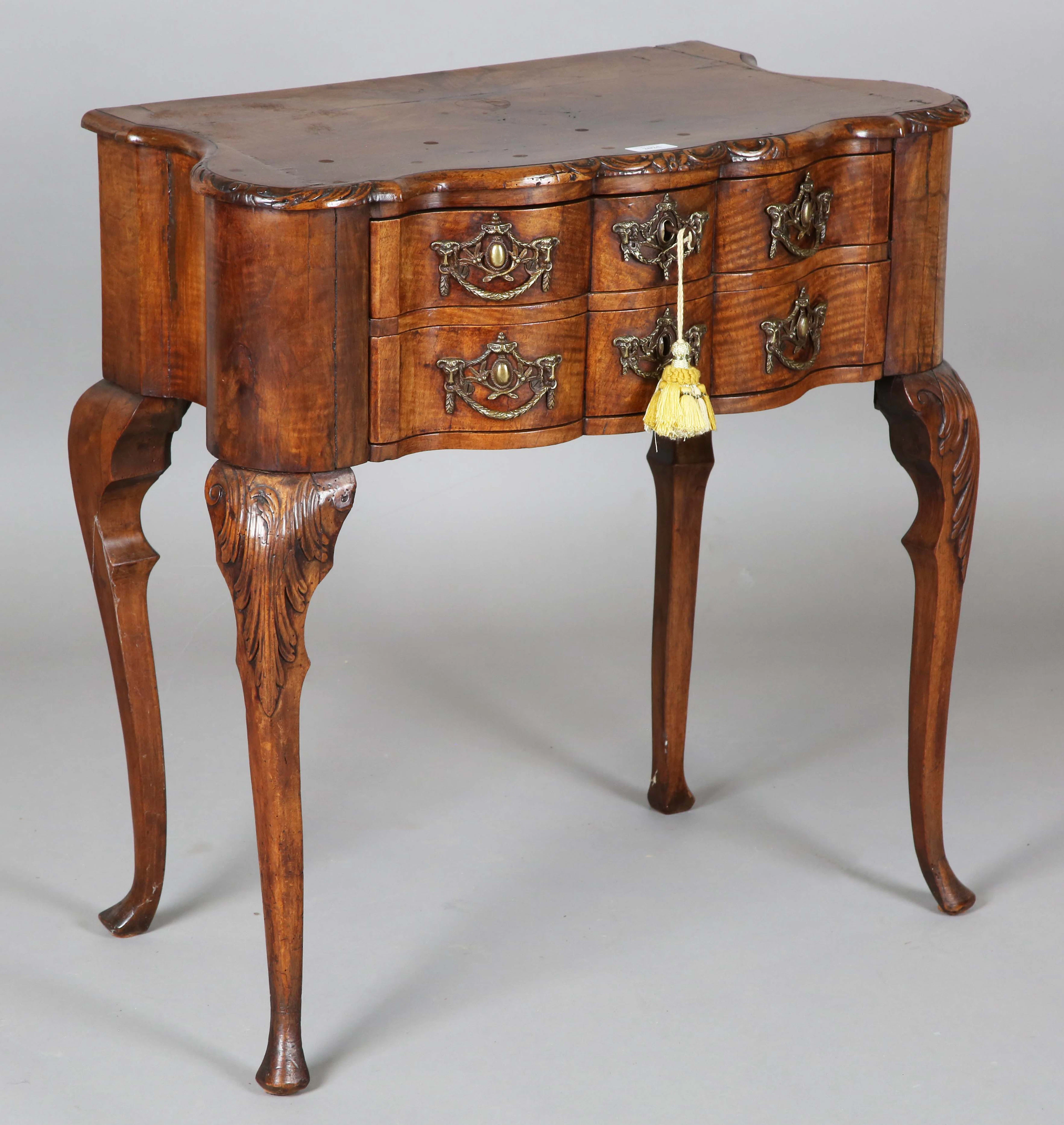 An 18th century Dutch walnut lowboy of serpentine form, fitted with