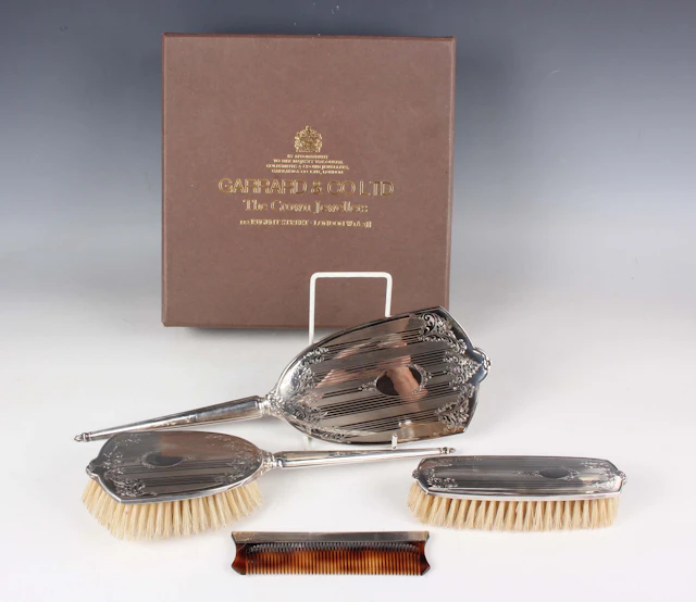 An Elizabeth II silver four-piece dressing table set, engraved with