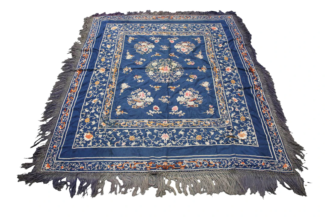 A Chinese blue silk and embroidered table cover, finely worked in