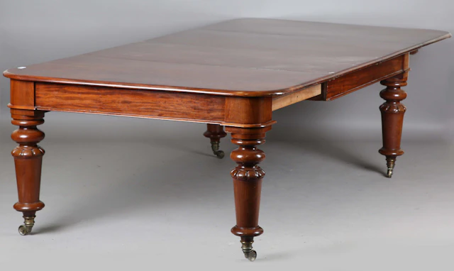 A large mid-Victorian mahogany extending dining table, the top with