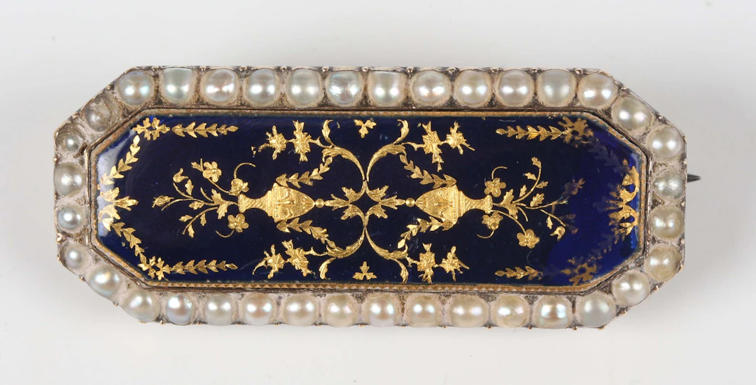 A gold, silver, half-pearl and enamelled cut cornered rectangular