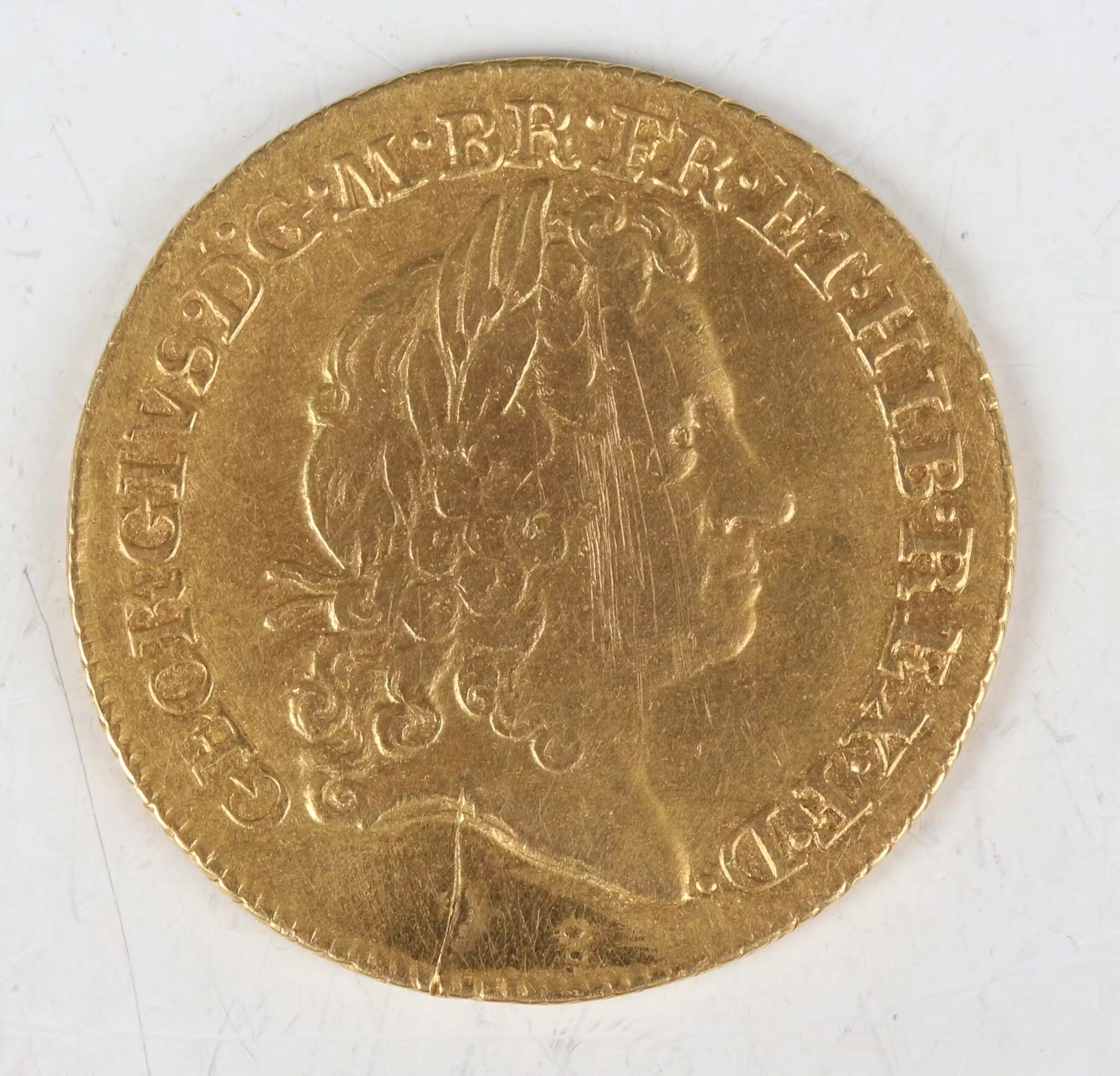 A scarce George I guinea 1715, third laureate head, no hair below