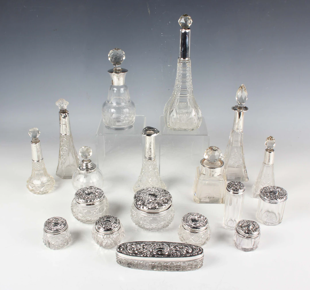 A group of nine silver lidded cut glass dressing table jars, various