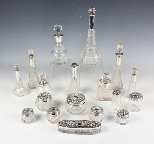 A group of nine silver lidded cut glass dressing table jars, various